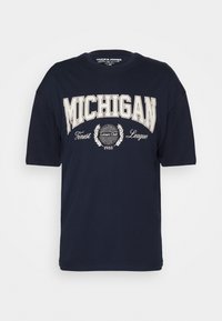 Camiseta de algodón azul marino de mangas cortas, con texto impreso en blanco "MICHIGAN", adornos decorativos y diseño de cuello redondo.
