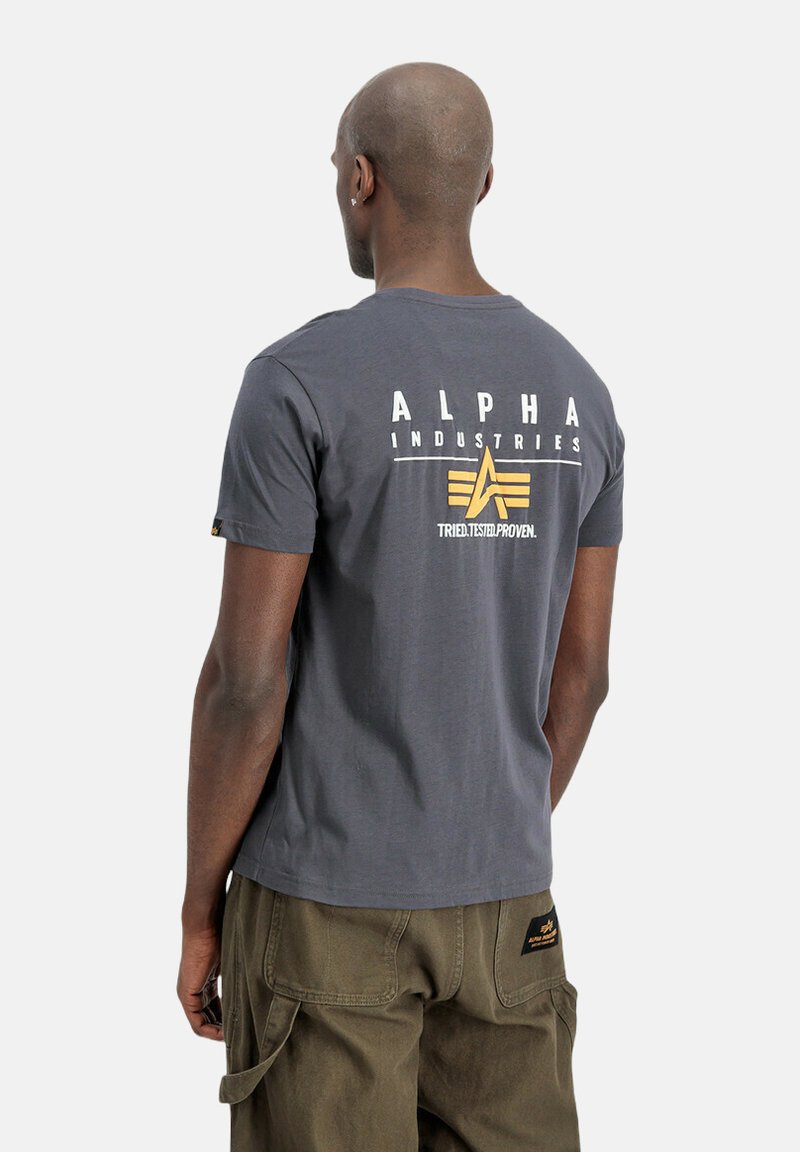 Hallgris puuvillane t-särk valge ja kollase trükiste ning logoga seljal. Klassikaline ümmarguse kaelusega disain, lühikesed varrukad ja mugav lõige.