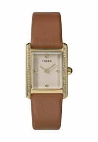 Montre Timex rectangulaire avec un cadran beige, un boîtier en métal doré, un bracelet en cuir marron et des accents en cristal autour du visage.