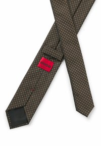Ruskea kuviollinen solmio, jossa on geometrinen muotoilu, valmistettu sileästä kankaasta. Sisältää punaisen lapun, jossa on mustalla tekstillä "HUGO" ja "MADE IN ITALY".