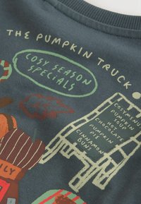 Text "Pumpkin Truck" s podzimními listy, ilustrací dýně a cedulí s nabídkou sezónních specialit jako polévka, koláč a bulky.