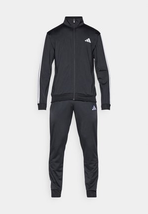 Must Adidas dressipluus valgete triipudega varrukatel ja pükstel, lukuga jakk, soonikkoes mansetid ning Adidas logo rinnal ja reiel.