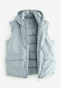 Gai pelēks pūku vests ar kapuci, spiedpogām un divām priekšējām kabatām. Piedāvā quiltēta tekstūra un rāvējslēdzējs priekšpusē.