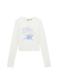Witte lange mouwen crop top met blauwe grafische tekst "Guess Originals" en sterontwerp. Zachte katoenen stof met scalloped zoomdetail.