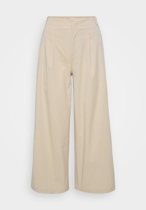 Beige weite Hose aus glattem Stoff, mit hohen Taillenbund, Vorderfalten und einem knöchellangen Saum. Einfaches und ungeschmücktes Design.