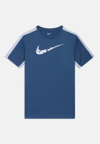 Σκούρο μπλε μπλουζάκι Nike με γαλάζιους ώμους, διαθέτει λευκό λογότυπο Nike Swoosh παραμορφωμένο στο στήθος. Κατασκευασμένο από μαλακό ύφασμα.