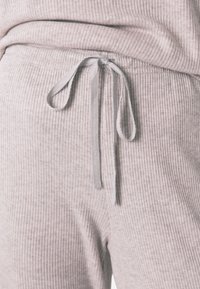 Behagelige, lysegrå ribbede sweatpants med en snøre i taljen og textureret stof. Har en afslappet pasform og elastisk kant.