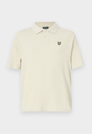 Polo cu mânecă scurtă, de culoare crem deschis, dintr-un material texturat, având un guler pliat și un logo brodat de culoare verde închis pe piept.