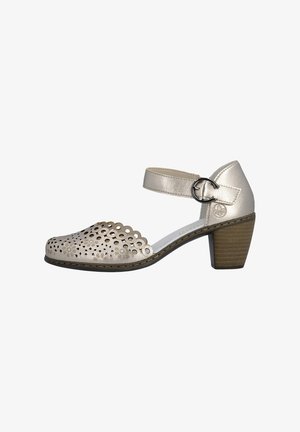 Chaussure à talon bloc bas pour femme en beige métallique avec bride à la cheville, boucle ronde et motif floral découpé sur la zone des orteils.