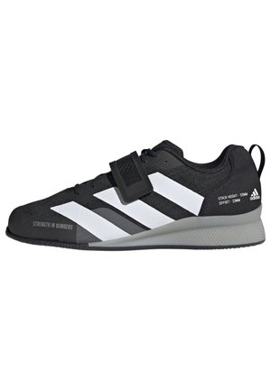 Chaussure d'haltérophilie noire Adidas avec des bandes blanches, une fermeture velcro et une semelle grise, avec le texte "Strength in Numbers" sur l'orteil et les détails de la marque au talon.