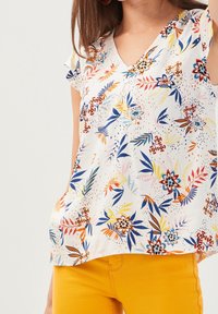 Hvid kortærmet bluse med V-hals og blomsterprint i blå, orange og pink, lavet af letvægtsstof, afslappet pasform.