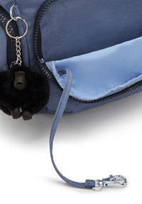 Borsa in nylon blu con un interno liscio, dotata di un portachiavi a forma di gorilla nero peloso e un gancio argentato sul tirante della cerniera.