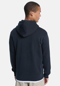 Navy blue hooded sweatshirt featuring a soft texture, ribbed cuffs, and a kangaroo pocket, designed with a relaxed fit and minimal accents.