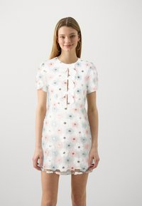 Λευκό floral φόρεμα με ροζ και μπλε κεντημένα λουλούδια, κοντά μανίκια, στρογγυλή λαιμόκοψη και τρεις λεπτομέρειες με κουμπιά, συνοδευόμενο από μια κορδέλα.