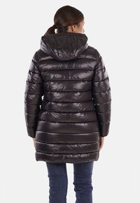 Cappotto bomber nero con cappuccio, caratterizzato da un design trapuntato e una finitura lucida. Ha una lunghezza media con polsini elasticizzati e una chiusura con zip laterale.
