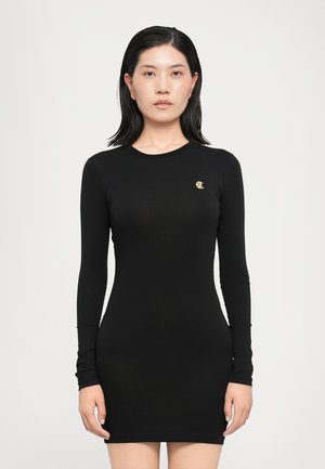 Black long-sleeve dress made of soft, stretchy fabric. Fitted design with a round neckline and a small gold logo on the chest.