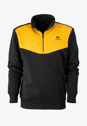 Sudadera de media cremallera en negro y amarillo con un cuello alto, hecha de un tejido suave. Presenta un diseño en forma de chevron, un logo en el pecho y puños acanalados.