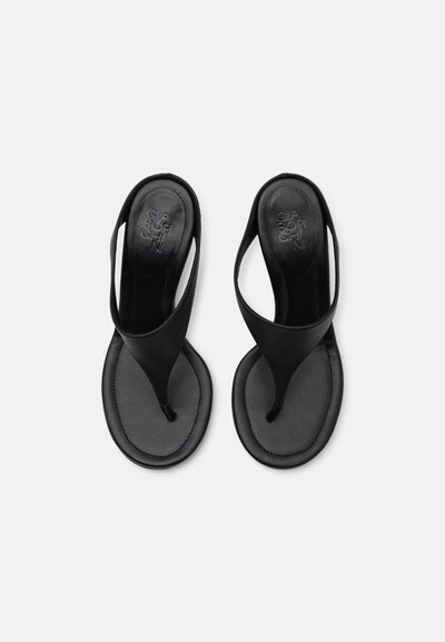 Sandale negre din piele, cu un stil tip thong, având o textură netedă și un design simplu. Talpă plată cu un logo subtil embosat.