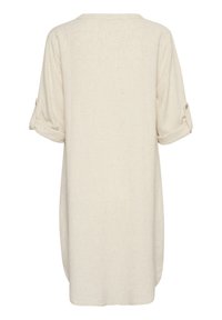 Tunic oversized beige chiaro con maniche arrotolate, tessuto texturizzato, orlo arrotondato e un semplice design sul retro.