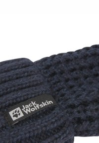 Dunkelblaue gestrickte Mütze aus strukturiertem Material, mit schwarzem Etikett und weißem "Jack Wolfskin"-Logo sowie Pfotenabdruck-Design.