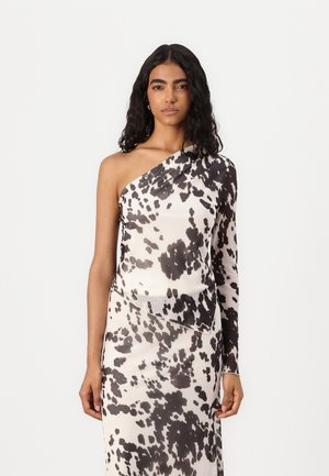 Vestido de un solo hombro en tejido liviano con un patrón abstracto de manchas en blanco y negro, silueta ajustada y detalles drapeados.