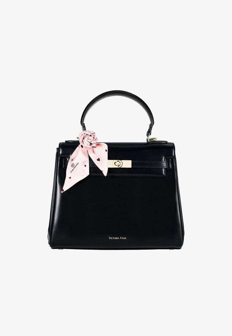 Sac à main en cuir noir avec fermoir doré et poignée unique, décoré d'un foulard rose noué en forme de fleur sur la poignée.