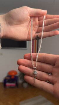 Strieborný náhrdelník s príveskom v tvare ruže, hladký povrch, prepracované detaily na okvetných lístkoch a stonke, s dizajnom spojenej retiazky.