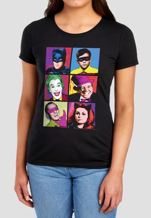 Frau trägt schwarzes T-Shirt mit farbenfrohen Pop-Art-Gesichtern von sechs klassischen Batman-TV-Figuren in einem 2x3 Raster.