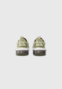 Green athletic shoes featuring a mesh upper, padded collar, translucent sole, and a logo on the back. Designed for comfort and breathability.