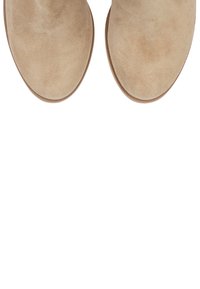 Beige velúr bokacsizmák lekerekített orral és alacsony, texturált gumitalppal. A felület sima és enyhén bolyhos.