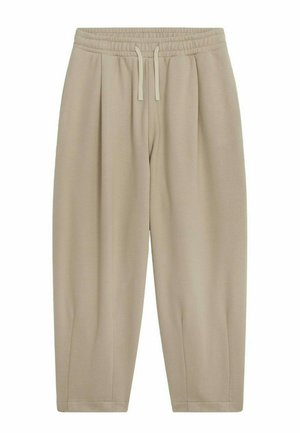 Pantalon de survêtement beige au fit décontracté, avec une taille élastique, un cordon de serrage et des chevilles fuselées. Fabriqué en tissu doux et lisse avec des plis sur les côtés.