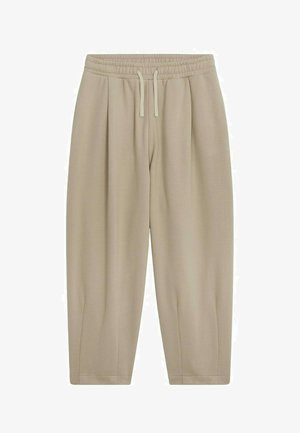 Pantalon de survêtement beige au fit décontracté, avec une taille élastique, un cordon de serrage et des chevilles fuselées. Fabriqué en tissu doux et lisse avec des plis sur les côtés.
