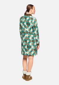 Langärmliges Kleid im türkisen, braunen und weißen Karomuster, mit einem Kragen und Manschetten im Leopardenmuster. Weiche Textur und knielangen Schnitt.