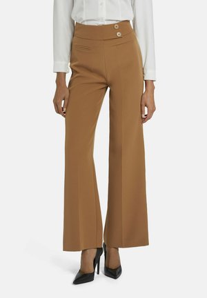 Bruine wijde broek met een hoge tailleband met twee knopen, zijzakken en een gladde textuur, gecombineerd met zwarte hoge hakken.