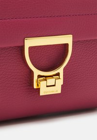 Coccinelle ARLETTIS SIGNATURE - Sac à main - rosewood