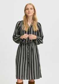 Schwarz-creamfarben gestreiftes Kleid mit tailliertem Bund, langen Puffärmeln und V-Ausschnitt. Leichter Stoff mit glatter Textur.