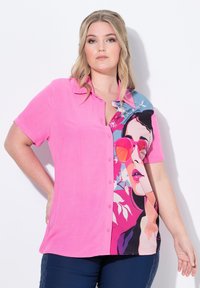Kurzärmliges Hemd in leuchtendem Pink mit einem mehrfarbigen grafischen Druck, der eine Frau mit Sonnenbrille und blumigen Akzenten zeigt.