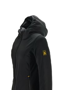 Giacca nera con cappuccio, dotata di zip frontale e tasche laterali. Tessuto liscio, toppa gialla con logo sulla manica, design elegante.