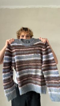 Πολύχρωμο ριγέ πουλόβερ από απαλό πλεκτό ύφασμα, με ρίγες σε μπλε, καφέ και λευκό. Διαθέτει στρογγυλή λαιμόκοψη και ριμπ τελείωμα.