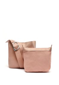 Borsa a tracolla in pelle rosa con una larga tracolla e hardware in argento, accompagnata da una pochette in tela abbinata più piccola. Entrambi presentano una texture liscia.