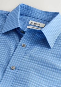 Chemise à carreaux bleu clair avec col pointu et deux boutons visibles, étiquetée comme coupe régulière de la collection Premium N.
