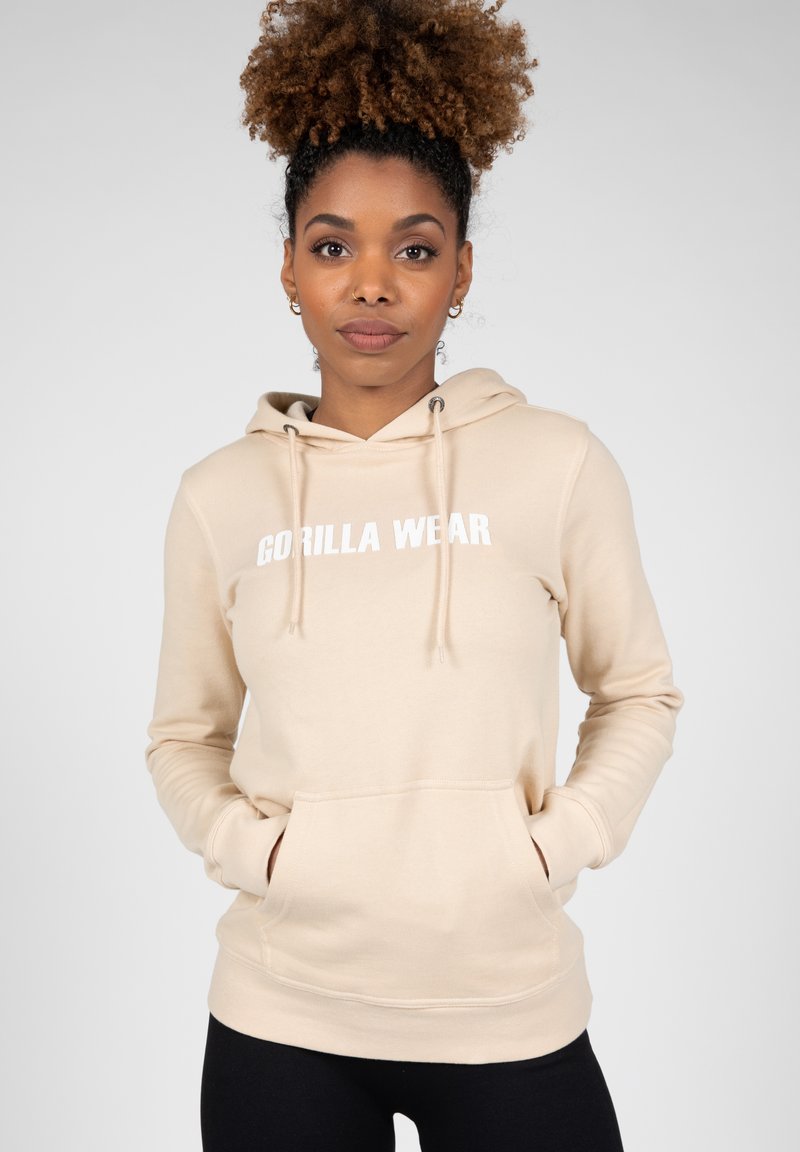 Beige hoodie met het "GORILLA WEAR" logo in het wit. Beschikt over een voorkantvak, trekkoordcapuchon en lange mouwen. Gladde textuur.