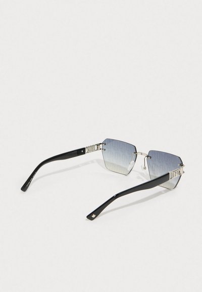 Gafas de sol hexagonales con un marco metálico plateado, lentes degradados en azul y brazos negros brillantes con acentos de logo cerca de las patillas.