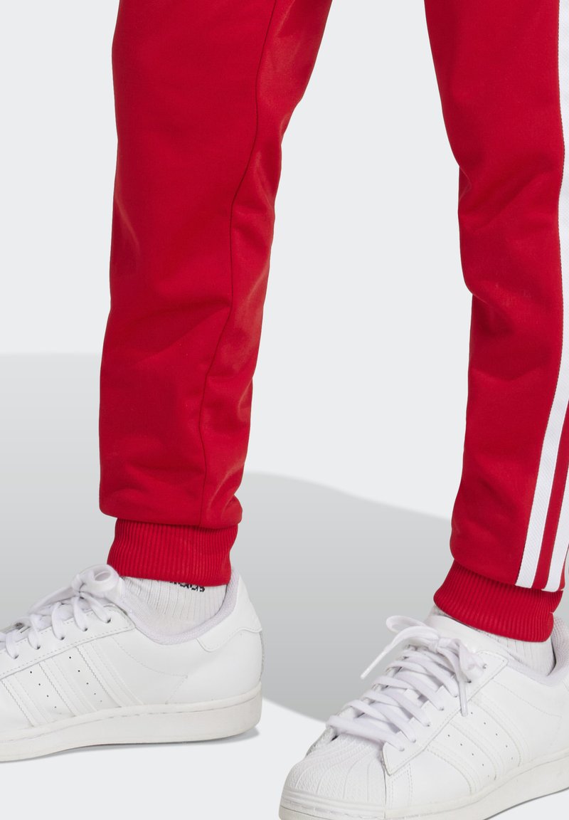 adidas Originals SUPERSTAR - Tracksuit bottoms - better scarlet/red -  Zalando