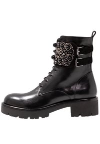 Stivaletto in pelle nera con pannello testurizzato, borchie decorative e perline, doppia fibbia e suola in gomma spessa.