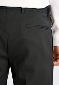 Czarne spodnie w kant o gładkiej fakturze, slim fit i tylnym kieszeni z delikatnym szwem. Idealne na formalne okazje.