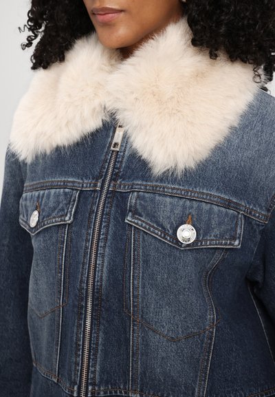 Denim jakk, millel on hele tehisnahast krae. Omab lukku, two rinna taskut koos hõbedaste detailidega ja tume sinine pesu.