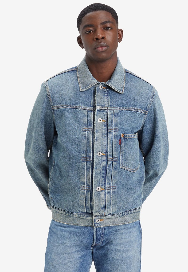 Jachetă din denim albastru deschis, cu închidere butonată, guler ascuțit, buzunar pe piept și buzunare laterale. Finisaj uzat cu detalii de cusătură vizibile.