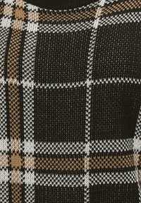 Neulepaita, jossa on musta, ruskea ja valkoinen ruudullinen kuvio. Sisältää tekstuuripintaisen kankaan ja pyöreän kaula-aukon, jossa on erottuvat saumat.