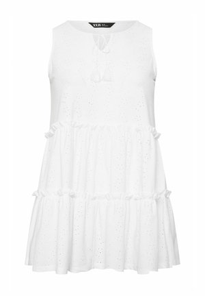 Weißes ärmelloses Kleid mit rundem Ausschnitt, mit Ösen-Details, einem gestuften Rüschensaum und dekorativen Bändern mit Quasten am Ausschnitt.